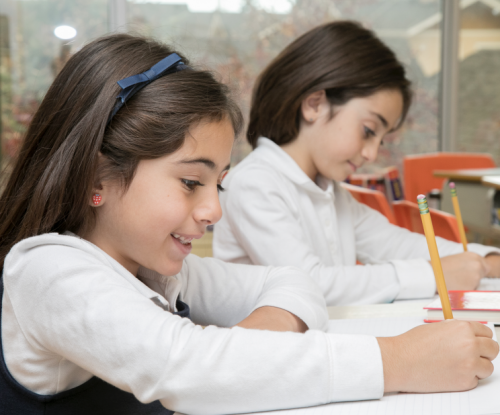private school girls writing at their desk