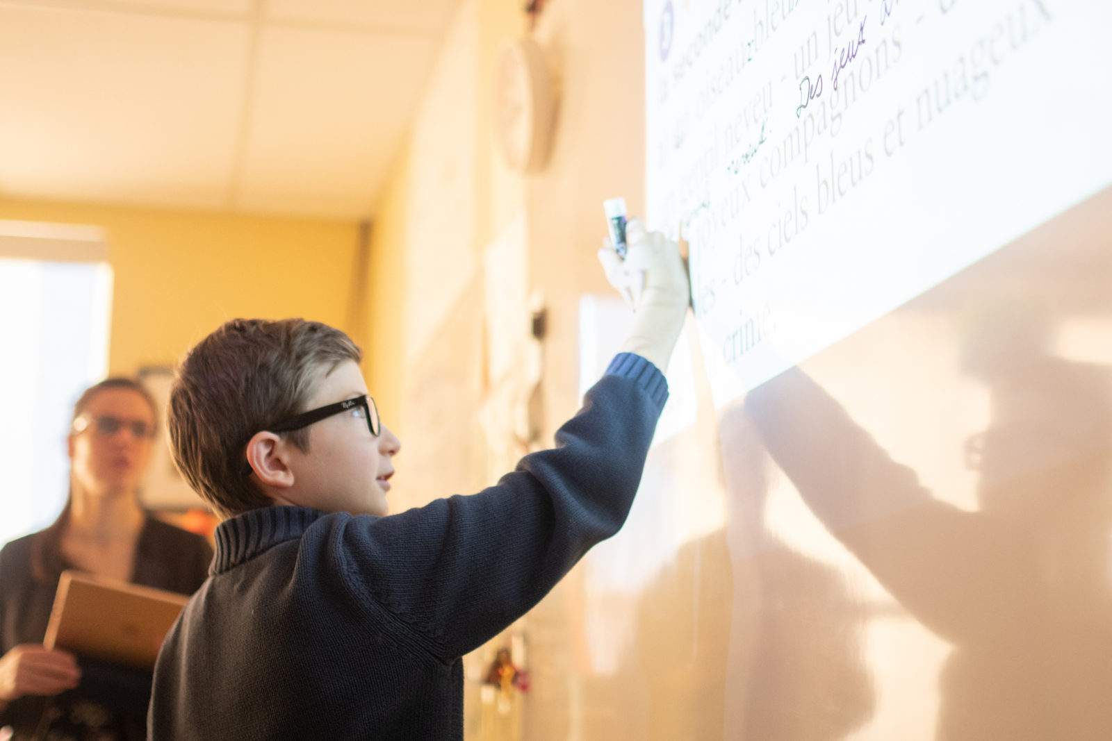 Private school student writing on white board